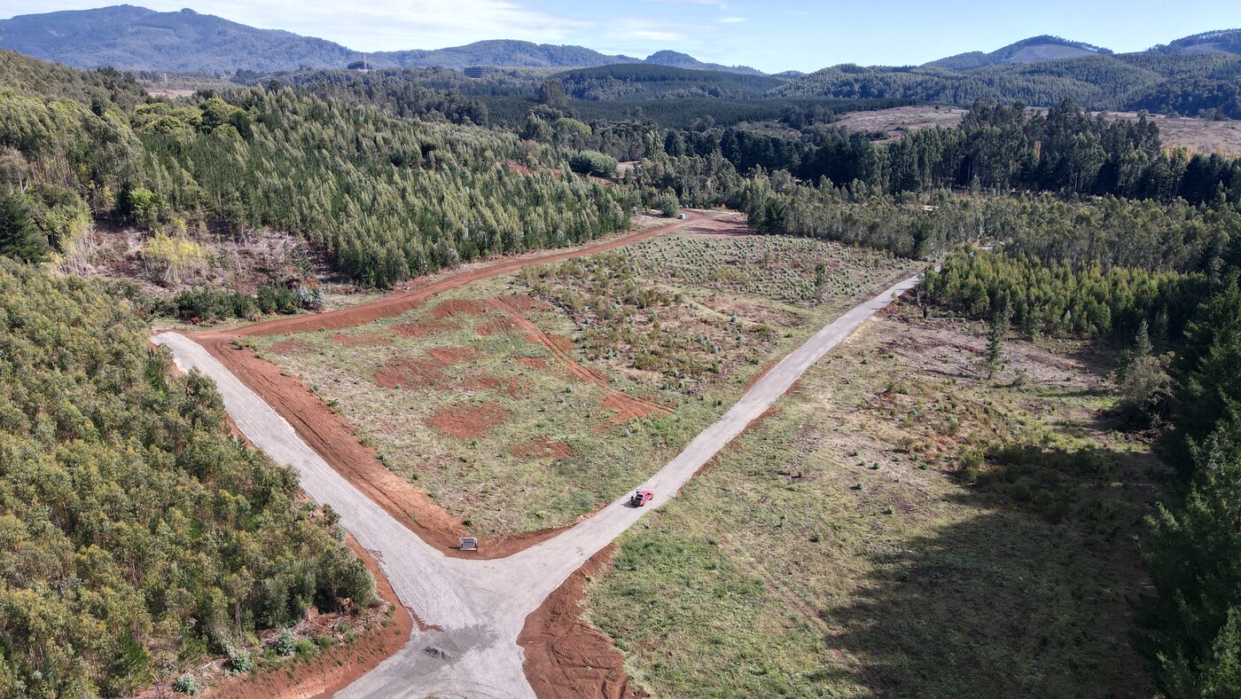 Vista aérea panorámica de Refugio Pumalal con parcelas, caminos y bosque